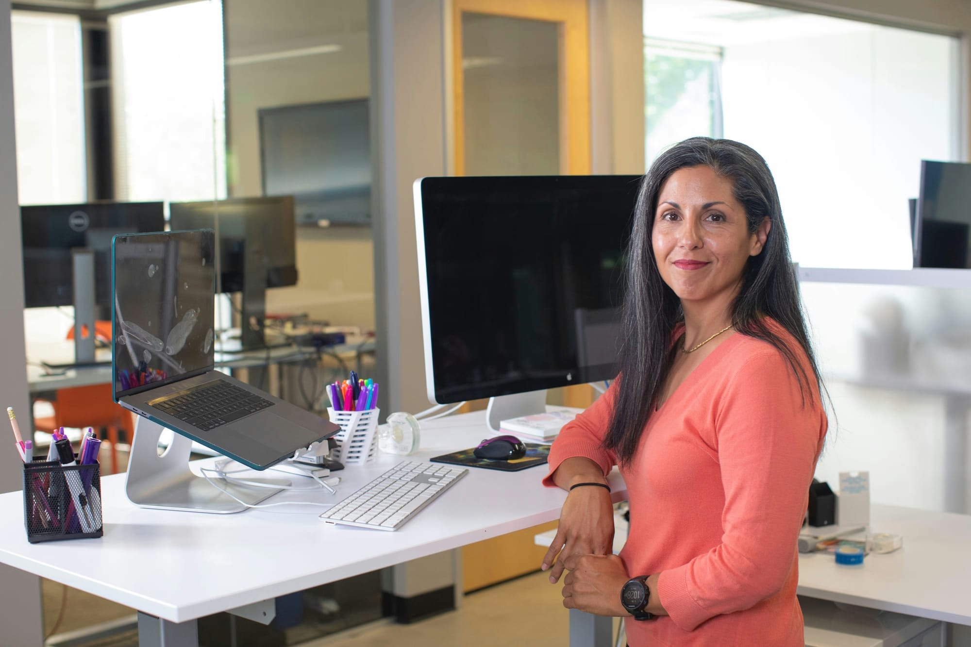 A lady sitting in an office setting posing for a headshot with office headshot background